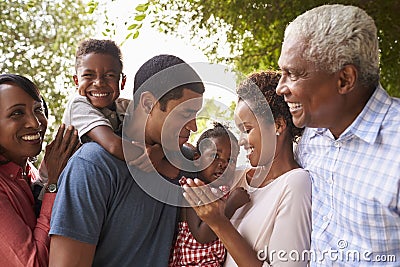 Multi generation black family look at each other in garden Stock Photo