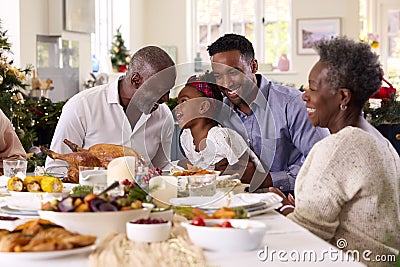 Multi-Generation Family Celebrating Christmas At Home With Grandfather Serving Turkey Stock Photo