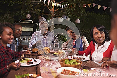 Multi generation family eating dinner in garden, close up Stock Photo