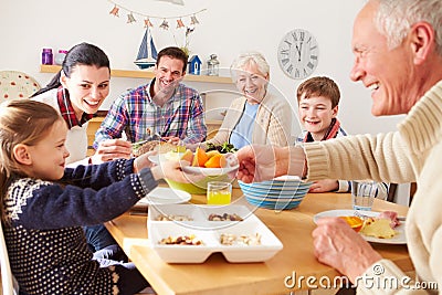 Multi Generation Family Eating Lunch At Kitchen Table Stock Photo