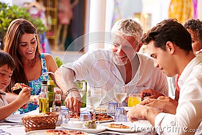 Multi Generation Family Eating Meal At Outdoor Restaurant Stock Photo