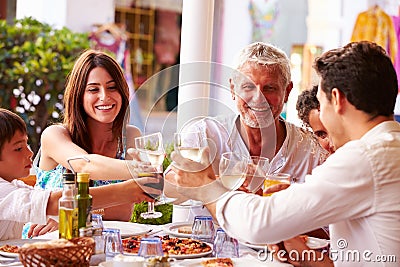 Multi Generation Family Eating Meal At Outdoor Restaurant Stock Photo