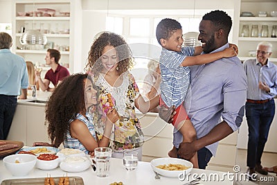 Multi-Generation Family And Friends Gathering In Kitchen For Celebration Party Stock Photo