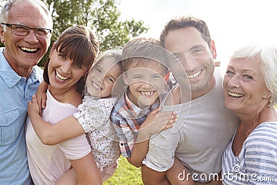 Multi Generation Family Giving Children Piggybacks Outdoors Stock Photo