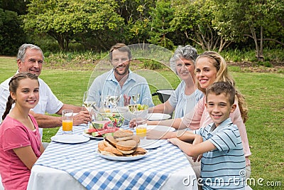 Multi generation family having dinner outside at picnic table Stock Photo