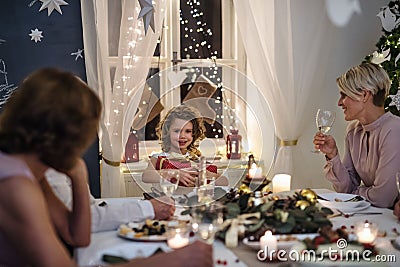 Multi-generation family indoors celebrating Christmas together, sitting at table. Stock Photo