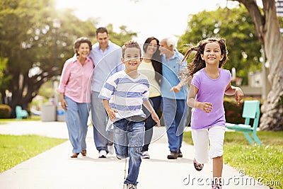 Multi Generation Family Walking In Park Together Stock Photo