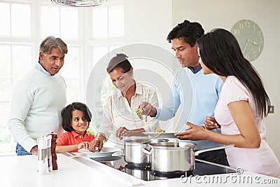 Multi Generation Indian Family Cooking Meal At Home Stock Photo