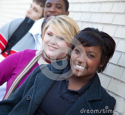 Multi-racial college students against a brick wall Stock Photo