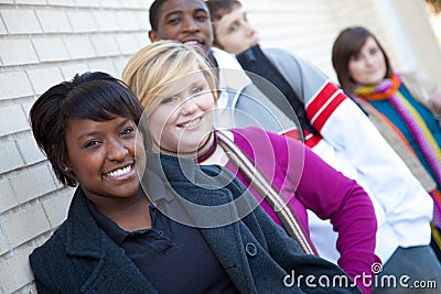 Multi-racial college students against a brick wall Stock Photo