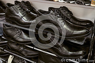 Multi-storey shelve with rows of black man off-season shoes Stock Photo