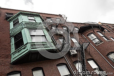 Multi story bumped out bay window with verdigris metal patina on old apartment building Stock Photo