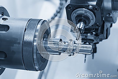 The multi tasking CNC lathe machine in metal working process milling the metal shaft parts . Stock Photo