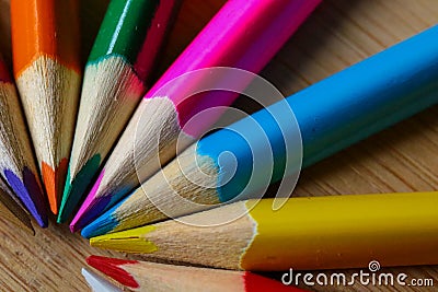 Multicolor pencils forming a color half circle isolated on wooden background. Stock Photo