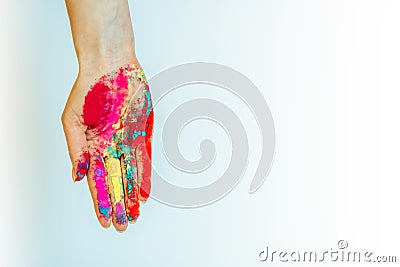Multicolor powdered paints on palm. Concept of Holi, Indian spring festival. Image of female hand on white background, copy space Stock Photo