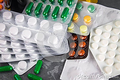 Multicolored blisters of tablets on a gray concrete background. Stock Photo