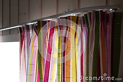 Multicolored bright curtain on the cornice, on the window. Stock Photo