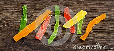 Multicolored candied fruits on a dark wooden background_ Stock Photo