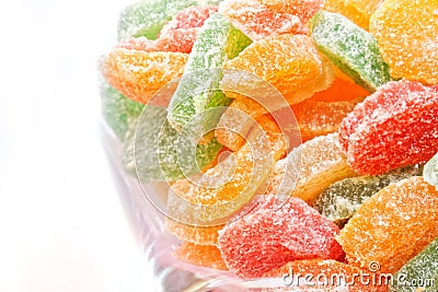 Multicolored candied fruits in a glass jar on a light background Stock Photo