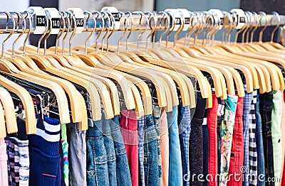 Multicolored casual clothing on wooden hangers Stock Photo