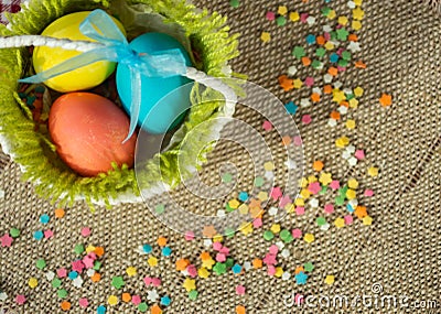 Multicolored eggs in easter festive basket on canvas napkin Stock Photo