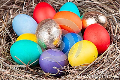 Multicolored eggs in nest in the hay. Concept easter Stock Photo