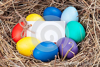 Multicolored eggs with a note in the hay. Mock up, concept easter Stock Photo