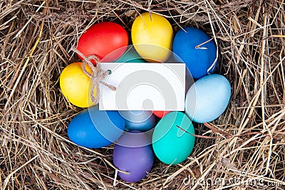 Multicolored eggs with a note in the hay. Mock up, concept easter Stock Photo