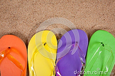 Multicolored flipflops in the sand Stock Photo