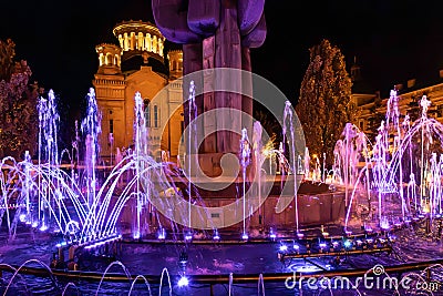 Multicolored illuminated fountain around the statue of Avram Iancu, located in Cluj-Napoca, Romania Stock Photo