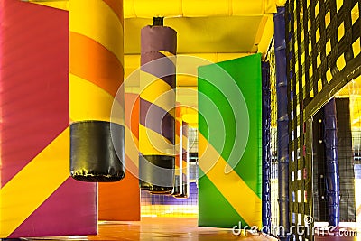 Multicolored labyrinth with hanging soft pillars and other obstacles in the children`s play complex Stock Photo