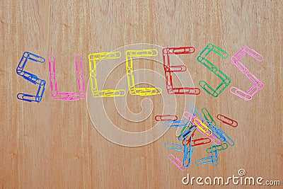 Multicolored of paper clips taken concatenation is the message that `SUCCESS` Stock Photo