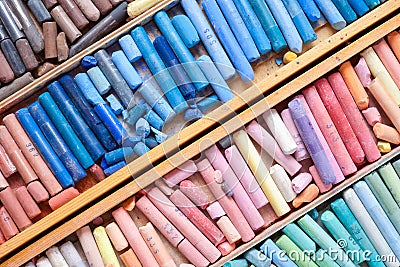 Multicolored pastel crayons in wooden artist box closeup Stock Photo