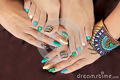 Multicolored pedicure and manicure with rhinestones on oval long female nails. Stock Photo