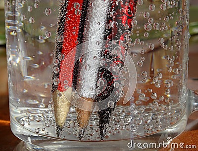 Colorful pencils immersed in a liquid make an interesting background. Stock Photo