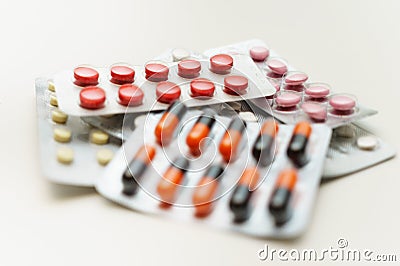 Multicolored pills and capsules in blisters close-up, on a white background. Soft focus. The concept of treating human diseases Stock Photo