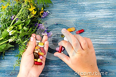 Multicolored pills, capsules in hand on blue background Stock Photo