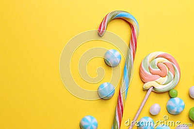 Multicolored round candy and colored lollipops on a yellow bright background. Stock Photo