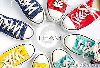 Multicolored sneakers on white background and word `TEAM` concept team work. Stock Photo