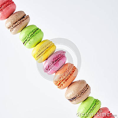 Multicolored stacked macarons on white background showing diagonal line, closeup view Stock Photo