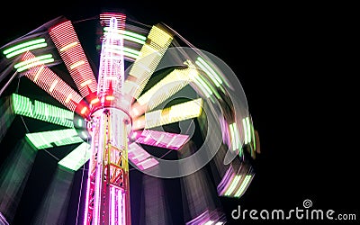 Multicolored Star Flyer tall Carousel rotating on long chains in an amusement park. Entertainment and leisure activities concept Stock Photo