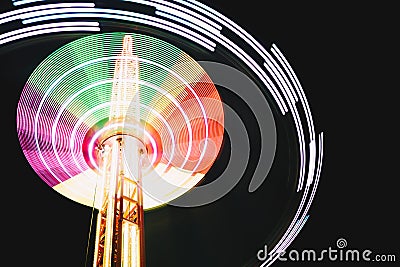 Multicolored Star Flyer tall Carousel rotating on long chains in an amusement park. Entertainment and leisure activities concept Stock Photo