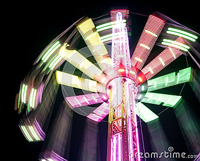 Multicolored Star Flyer tall Carousel rotating on long chains in an amusement park. Entertainment and leisure activities concept Stock Photo