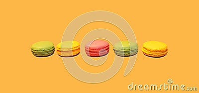 Multicolored sweet macaroons on yellow background Stock Photo