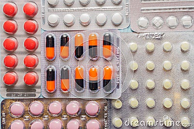 Multicolored tablets and capsules in blisters close-up, top view. The concept of treating human diseases Stock Photo