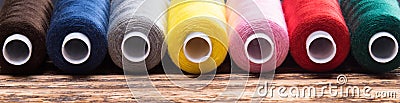 Multicolored threads in coils lie in line, long background Stock Photo