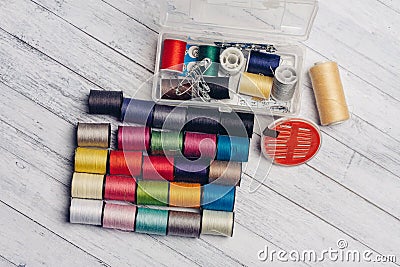 multicolored threads and other sewing accessories on the table needles pins fastener Stock Photo