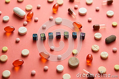 Multicolored title DEPRESS from black cubes on the table with tablets on coral background. Stock Photo