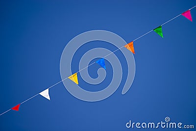 Multicolored Triangular Flags Hanging in the Sky at an Outdoor Stock Photo