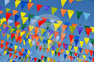 Multicolored triangular small flags to celebration party against blue sky as a background.Street holiday concept. Stock Photo